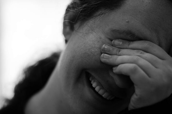 Photograph of a woman laughing with embarrassment