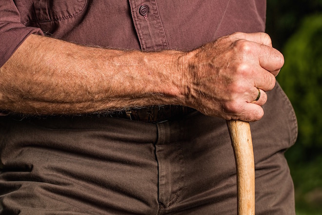 Photo of an elderly man holding a walking stick