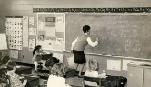 Teacher writing Hebrew on a chalkboard