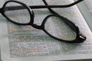 Glasses laid on an open Bible