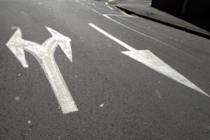 Arrows going in different directions, painted on the street.
