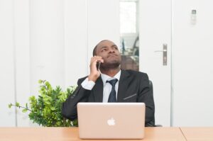 A business man on a phone call seemingly not liking what he hears.