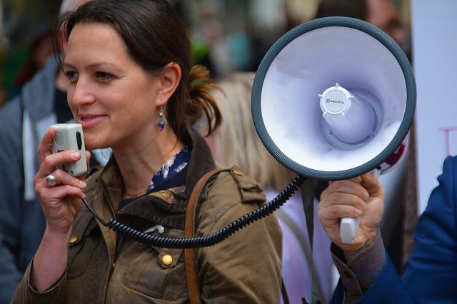 A woman using a loud speaker to amplify her voice.