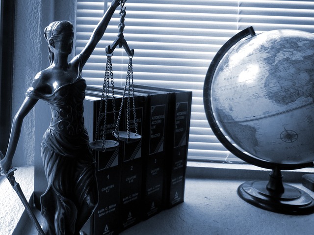 Symbols of legal justice: statue of Lady Justice, law books, a globe.