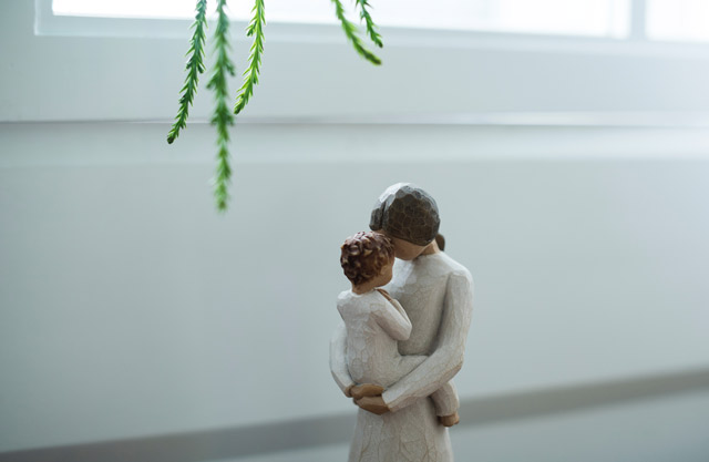 Figurines of a woman holding and comforting her small child.