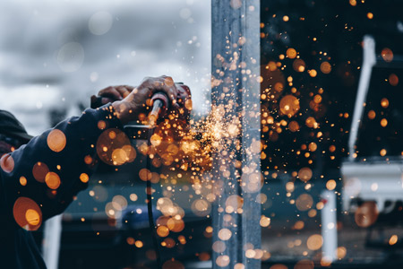 Sparks flying, as a worker polishes metal.
