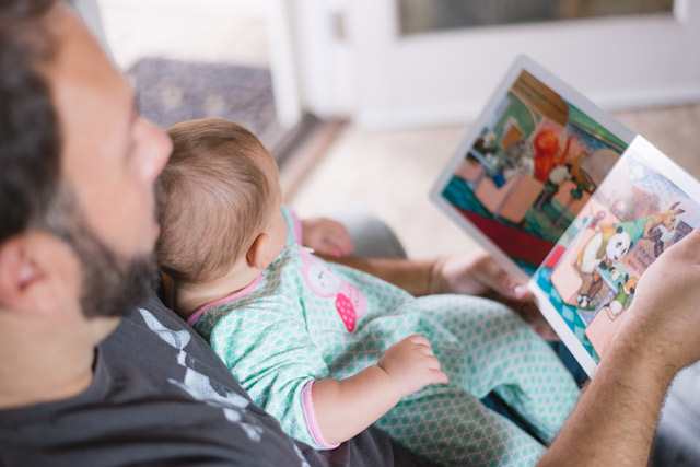 A father reading a picture book to his child.