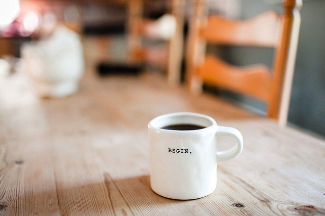 A mug of coffee on a long table.
