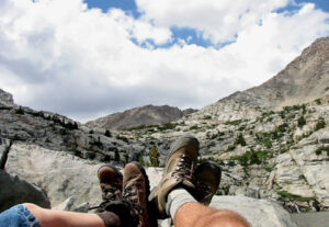 The boots of two people sitting and looking out over the Sierra