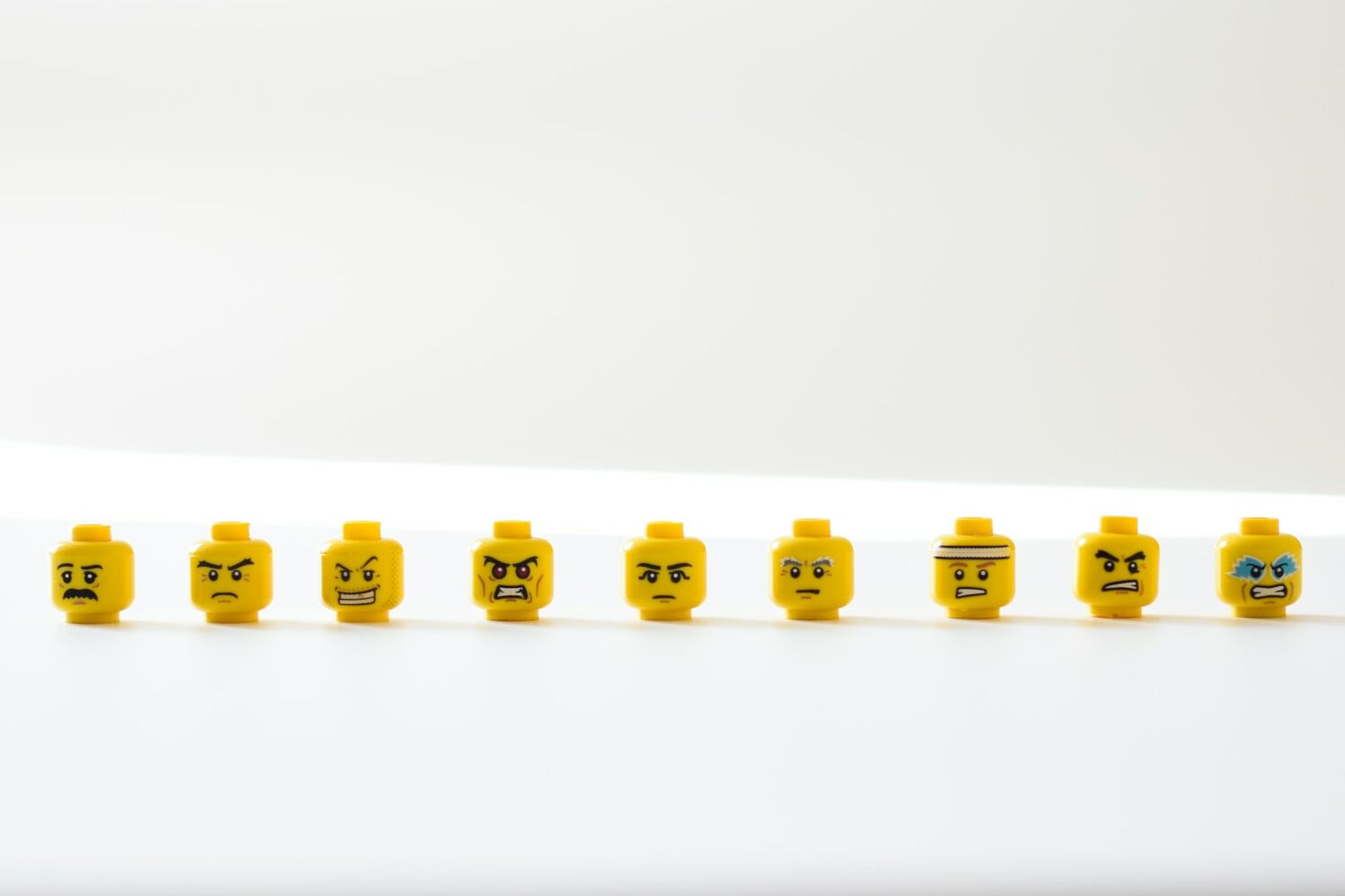 A row of Lego heads, each with a different expression