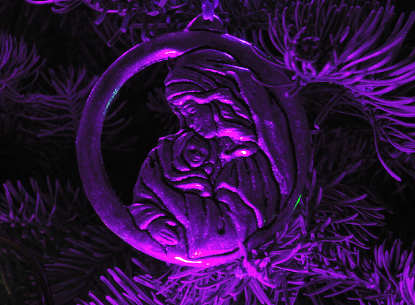 An ornament showing Mary and the baby Jesus in a soft purple light